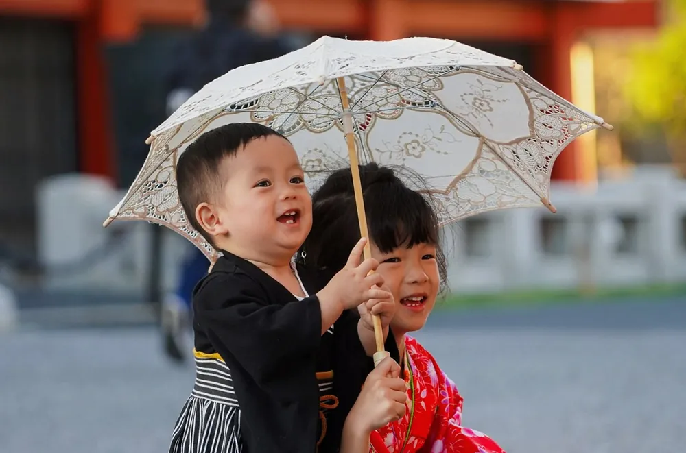 日傘を持って笑う、着物姿の子どもたち(イメージ写真)